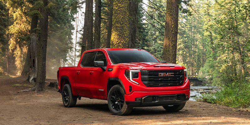 Red GMC Sierra 1500 on forest trail